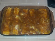 Burritos topped with enchilada sauce and going back in the oven.