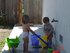 Hunter and Jordan play with the faucet.