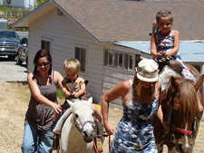 Natalie with AJ and Olivia on the ponies.